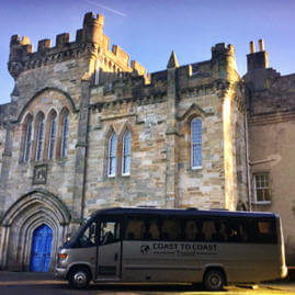 33 seater midi coach parked outside grand building