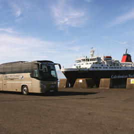 49 seater luxury coach parked at Ardrossan Harbour with the CalMac Arran ferry in the background